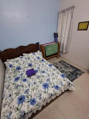 a bedroom with a bed with a blue and white blanket at Serra Homestay at Apartment Bukit Permata, Lumut in Lumut