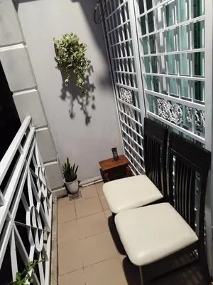 a balcony with two white chairs and a window at Serra Homestay at Apartment Bukit Permata, Lumut in Lumut