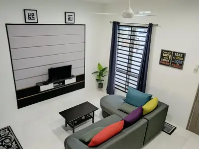 a living room with a couch and a tv at ShaFA Homestay in Seri Iskandar