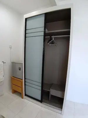 a glass closet with a glass door in a bathroom at ShaFA Homestay in Seri Iskandar