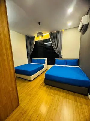 two beds in a room with blue pillows at Batu Ferringhi PoolBBQ 5minBeach Night Market20pax in Batu Ferringhi
