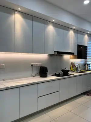 a kitchen with white cabinets and a counter top at Cozy Home Simpang Ampat in Simpang Ampat