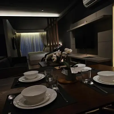 a table with plates and dishes on it in a living room at Black Martini Premium Suite in Tanjong Tokong