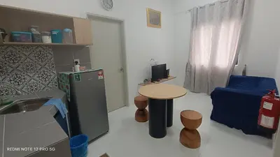 a small kitchen with a table and a refrigerator at ZIE HOMESTAY AT SOHO Seri Iskandar in Seri Iskandar