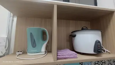 a cupboard with a toaster and a appliance on it at ZIE HOMESTAY AT SOHO Seri Iskandar in Seri Iskandar