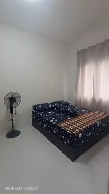 a bed in a room with a fan next to it at ZIE HOMESTAY AT SOHO Seri Iskandar in Seri Iskandar