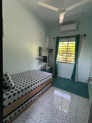 a bedroom with a bed and a window at Leman's Homestay in Balik Pulau