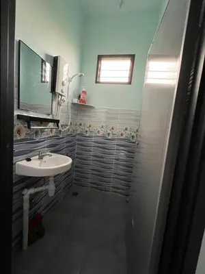 a bathroom with a sink and a mirror at Leman's Homestay in Balik Pulau