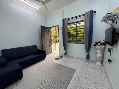 a living room with a couch and a window at Leman's Homestay in Balik Pulau