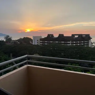 a view of the sunset from the balcony of a building at Batu Ferringhi Sri Sayang in Batu Ferringhi
