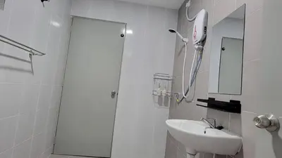 a bathroom with a shower and a sink and a mirror at Horizon Luxe WiFi n KTV in Sitiawan