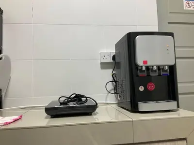 a computer printer sitting on a counter with a charger at Horizon Luxe WiFi n KTV in Sitiawan