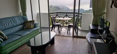 a living room with a couch and a table and a balcony at A23A5 Silverpark HighFloorView in Bukit Fraser