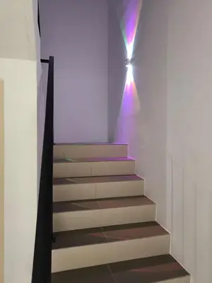 a staircase in a house with a light on the wall at De' Jamboree Homestay in Batu Gajah