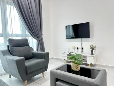 a living room with a chair and a tv at NEW Batu Kawan 2 Bedrooms Suite near IKEA-Columbia Asia Hospital-BKIP-UOW Kdu in Simpang Ampat