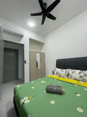 a bedroom with a green bed with a ceiling fan at NEW Batu Kawan 2 Bedrooms Suite near IKEA-Columbia Asia Hospital-BKIP-UOW Kdu in Simpang Ampat