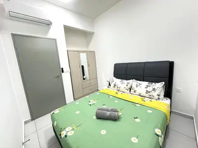 a bedroom with a bed with a green comforter at NEW Batu Kawan 2 Bedrooms Suite near IKEA-Columbia Asia Hospital-BKIP-UOW Kdu in Simpang Ampat