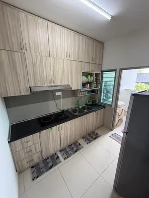 a kitchen with wooden cabinets and a black refrigerator at HSL Homestay Meru in Ipoh