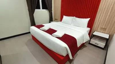 a bedroom with a large bed with a red headboard at The Corum View Hotel in Bayan Lepas