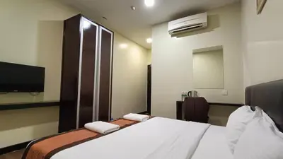 a hotel room with a bed and a tv at The Corum View Hotel in Bayan Lepas
