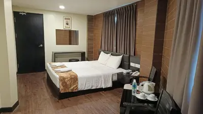 a hotel room with a bed and a table at The Corum View Hotel in Bayan Lepas