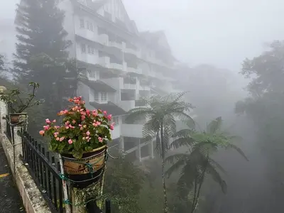 a apartment building in the fog with flowers on a fence at B10-5-1 Silverpark Resort -No Lift in Bukit Fraser