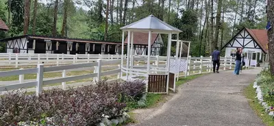 a white fence with a gazebo and people walking down a path at B10-5-1 Silverpark Resort -No Lift in Bukit Fraser