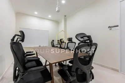 a conference room with a table and black chairs at 8 Concordia by YourSuperHost in George Town