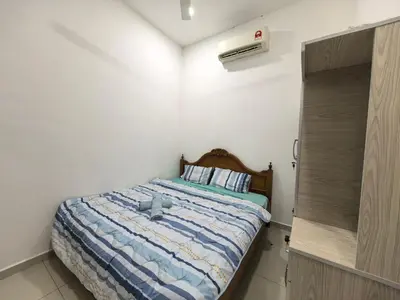 a bedroom with a bed with a blue comforter at Bertam Holiday Homestay 01 in Kepala Batas