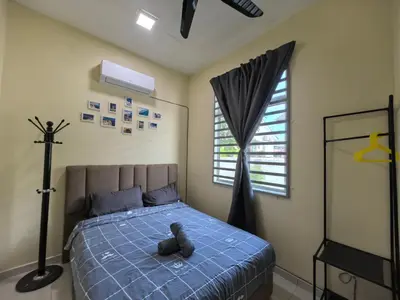 a teddy bear laying on a bed in a bedroom at Padang Serai Wangi Homestay 71 in Padang Serai