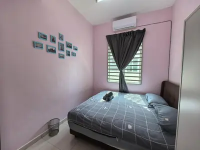 a cat laying on a bed in a room with a window at Padang Serai Wangi Homestay 71 in Padang Serai