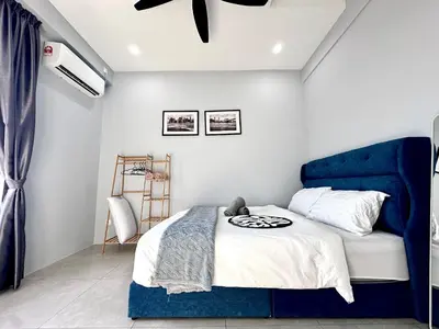 a bed with a blue headboard in a bedroom at Aston Acacia Residence Bukit Mertajam in Bukit Mertajam