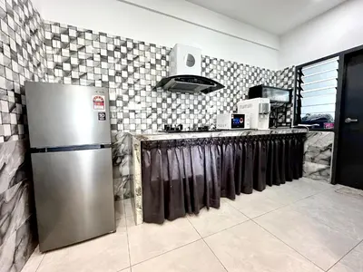 a kitchen with a stainless steel refrigerator and a counter at Aston Acacia Residence Bukit Mertajam in Bukit Mertajam