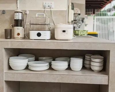 a shelf with plates and bowls on it in a kitchen at Mutiara Gurney bySOL at Genesis IVF, Gurney Paragon in George Town