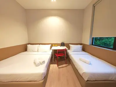 two beds in a room with a table and a chair at Mutiara Gurney bySOL at Genesis IVF, Gurney Paragon in George Town
