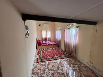 an empty room with a bed and a red rug at Homestay wak saripan Rumah Kayu in Teluk Intan