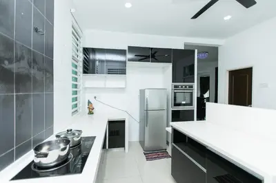 a kitchen with stainless steel appliances and black and white at Tanjung Bungah Villa 20 pax Mahjong Snooker and More Close to Beach in Tanjung Bungah