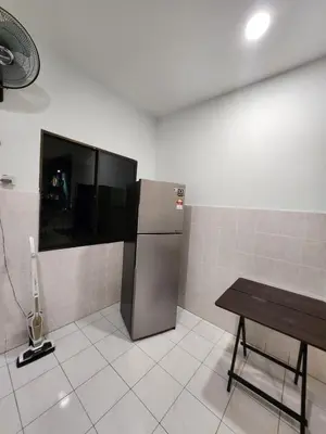 a kitchen with a refrigerator and a table in it at Ipoh pasir puteh vibrant home 4br 15 pax in Ipoh