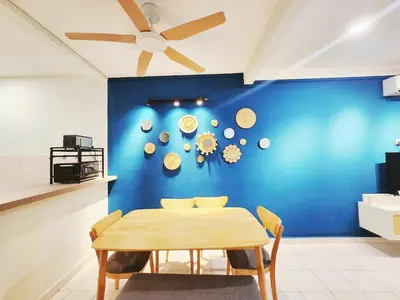 a dining room with a blue wall and a wooden table at Ipoh pasir puteh vibrant home 4br 15 pax in Ipoh