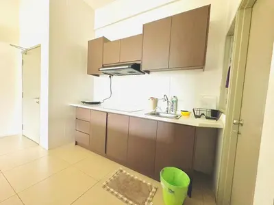 a kitchen with brown cabinets and a green trash can at Homestay Golden Hills in Brinchang