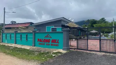 a building with a fence with a sign on it at Capital O 91205 Palong Hill Chalet & Resort in Baling