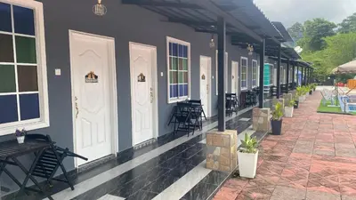 a building with chairs and tables on a patio at Capital O 91205 Palong Hill Chalet & Resort in Baling