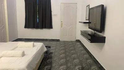 a bedroom with a bed and a tv on a wall at Capital O 91205 Palong Hill Chalet & Resort in Baling