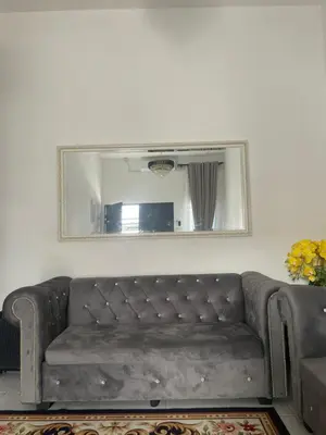 a couch in a living room with a mirror at Homestay Cikgu Ina in Kampong Chepor