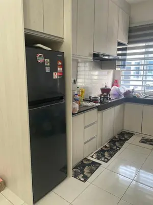 a kitchen with a black refrigerator in the corner at Homestay Cikgu Ina in Kampong Chepor