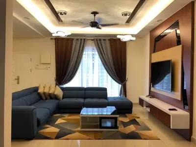 a living room with a blue couch and a tv at Casa Innova Homestay, Bertam Penang in Kepala Batas