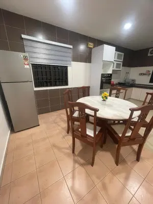 a kitchen with a table and chairs and a refrigerator at Ipoh Calm Corner in Ipoh