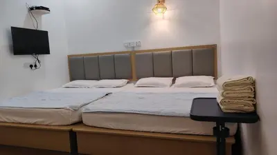 a bedroom with a large bed with a tv on the wall at Penang Hill Lodge in Ayer Itam