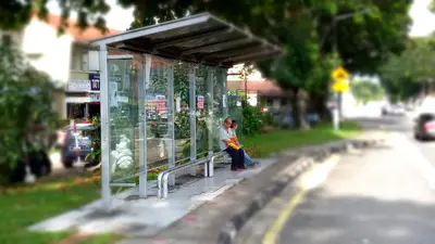 a woman sitting on a bench in a bus stop at Penang Hill Lodge in Ayer Itam