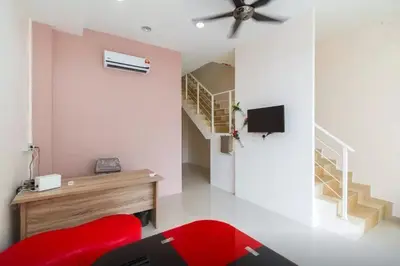 a living room with a red chair and stairs at Penang Hill Lodge in Ayer Itam